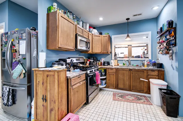 a kitchen with stainless steel appliances granite countertop a refrigerator a sink dishwasher a stove and white cabinets