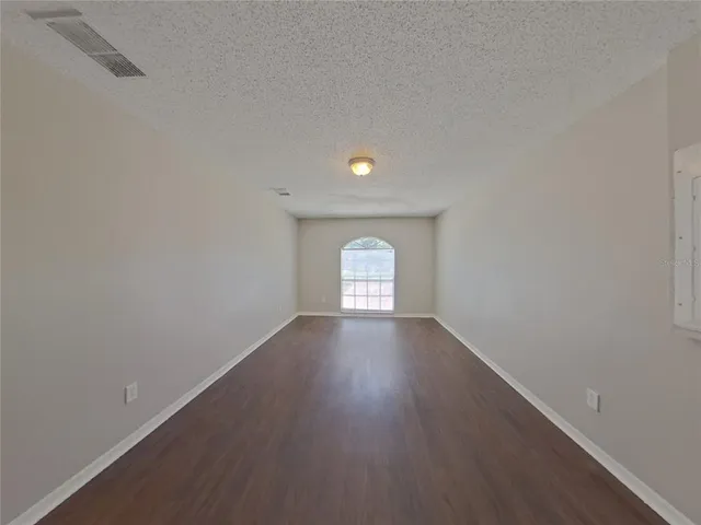 a view of a room with wooden floor and window