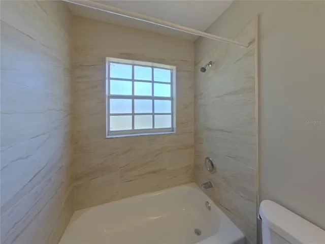 a bathroom with a bathtub and window