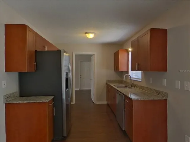 a kitchen with stainless steel appliances granite countertop a refrigerator and a sink