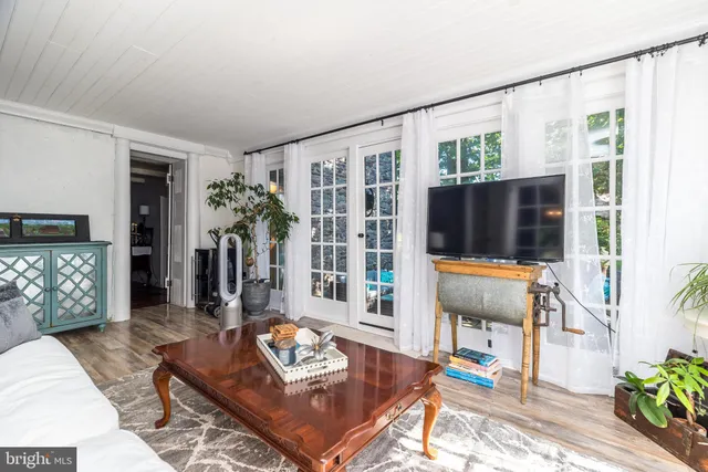 a living room with furniture a flat screen tv and a floor to ceiling window