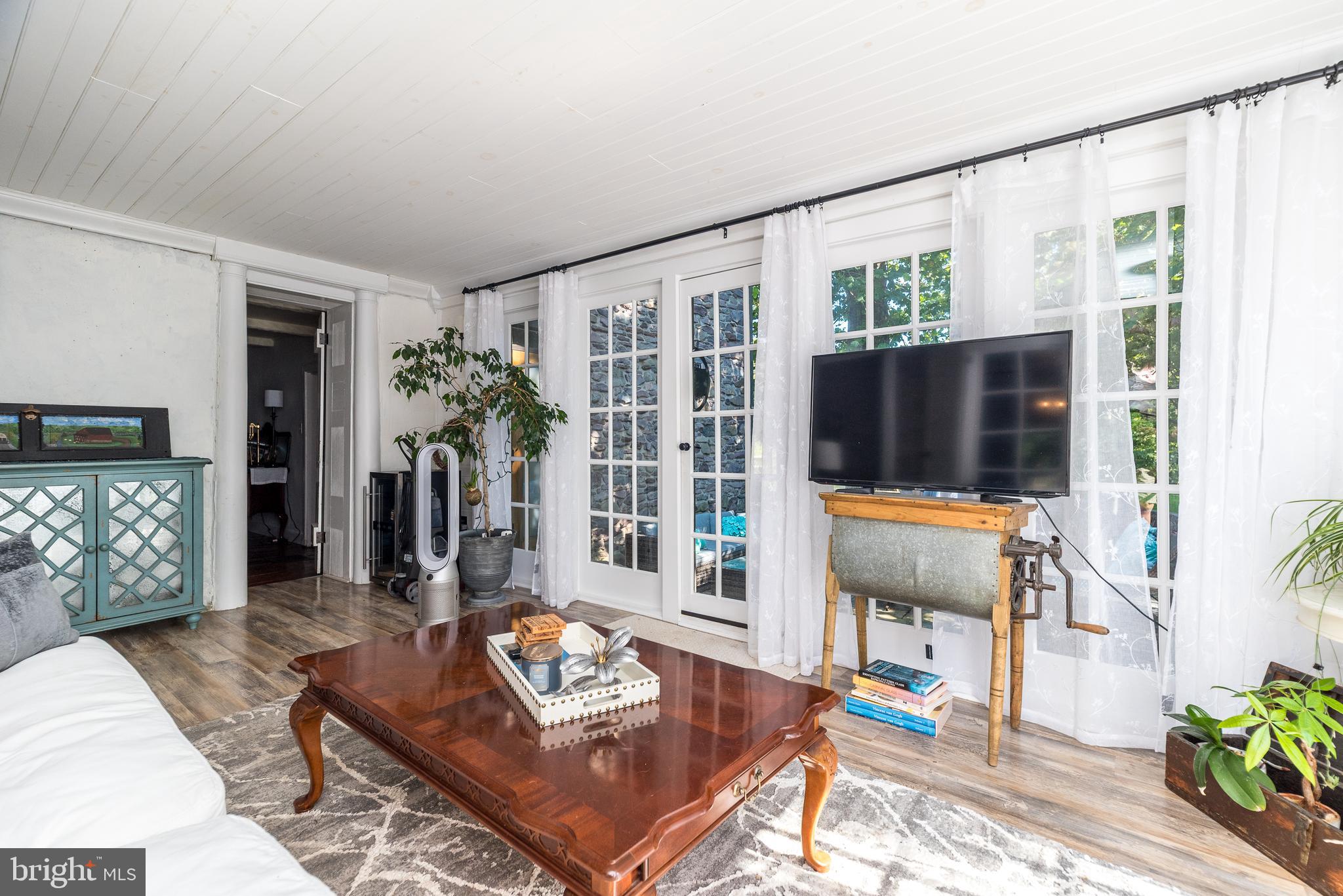 9022 Easton Road Ottsville, PA 18942 - Photo 11 of 45 a living room with furniture a flat screen tv and a floor to ceiling window