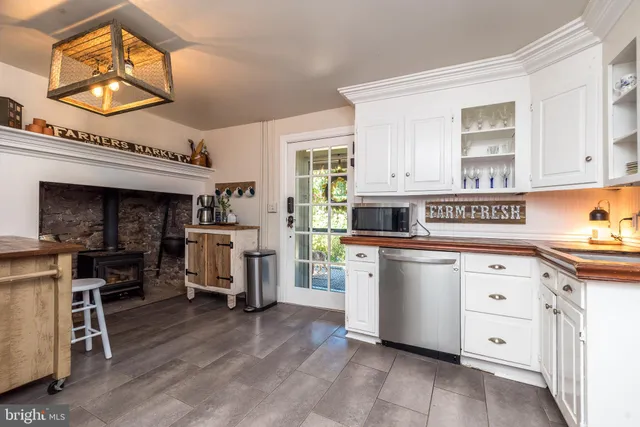 a kitchen that has a lot of cabinets in it and wooden floors
