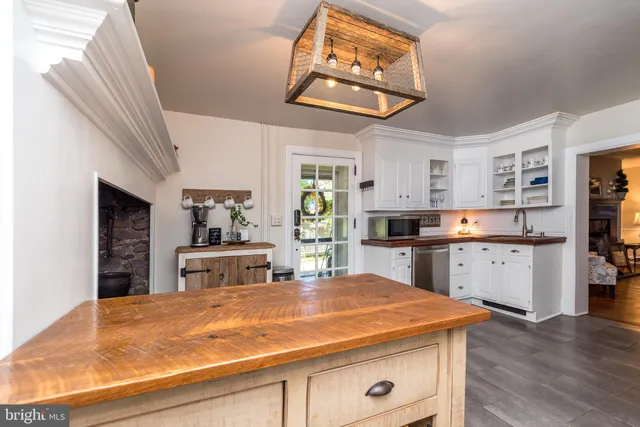 a kitchen with stainless steel appliances granite countertop a sink cabinets and wooden floor