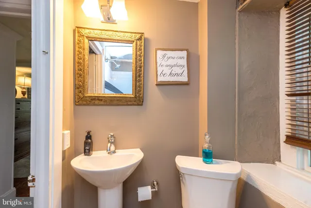 a bathroom with a toilet sink and mirror