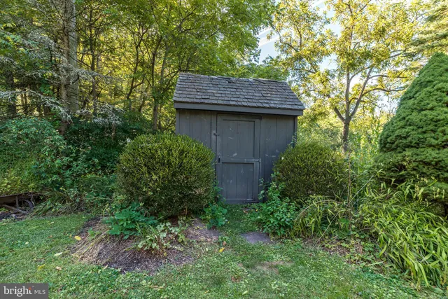 a backyard of a house with plants and tree