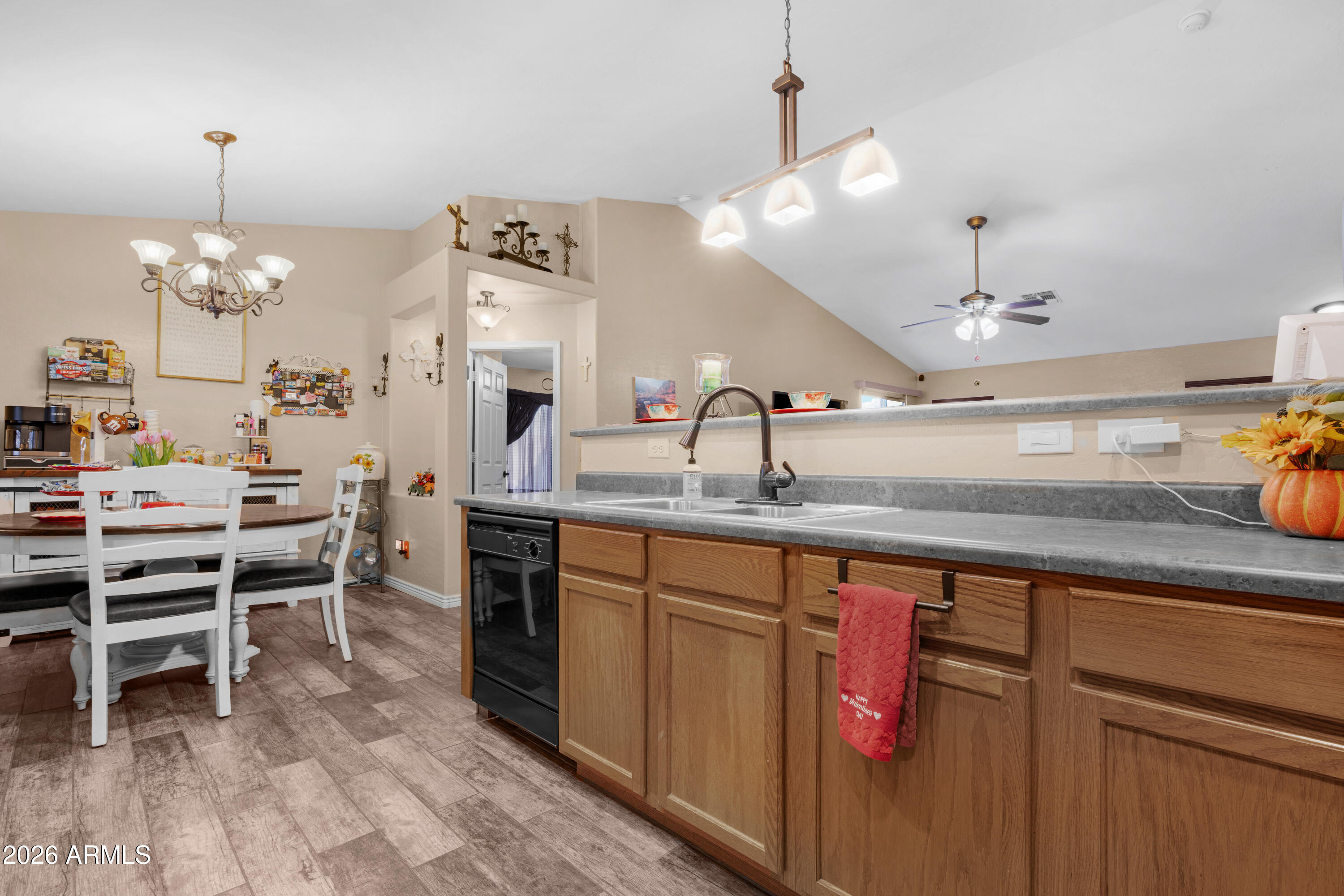 12018 West Almeria Road Avondale, AZ 85392 - Photo 11 of 39 a kitchen with kitchen island granite countertop a sink cabinets and wooden floor