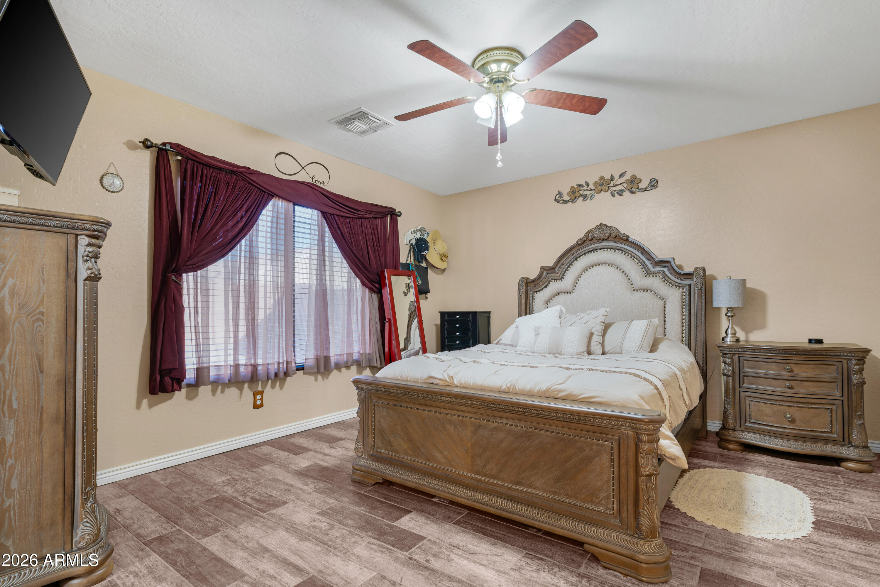12018 West Almeria Road Avondale, AZ 85392 - Photo 13 of 39 a bedroom with a bed and a flat screen tv