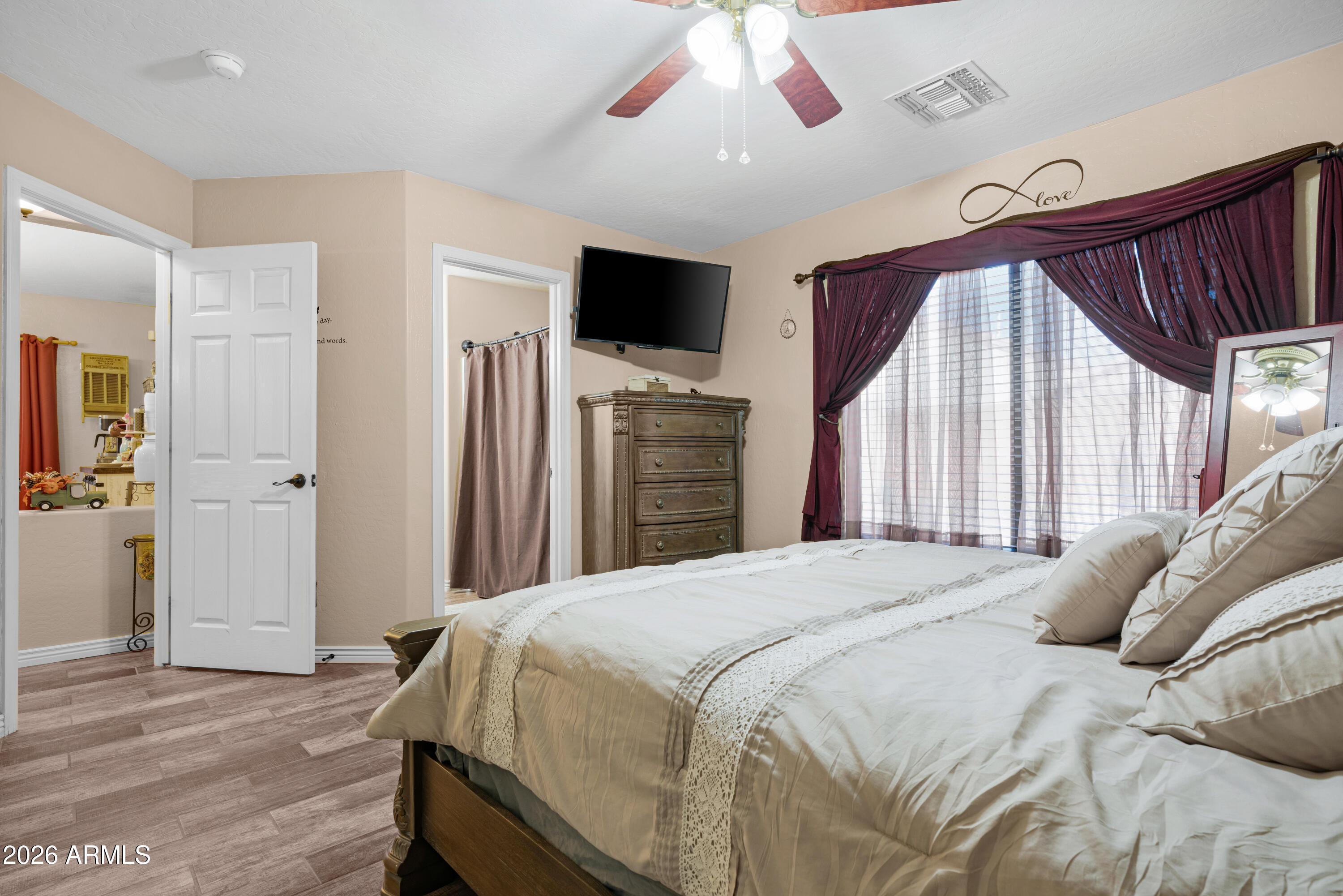 12018 West Almeria Road Avondale, AZ 85392 - Photo 15 of 39 a bedroom with a bed and a flat screen tv