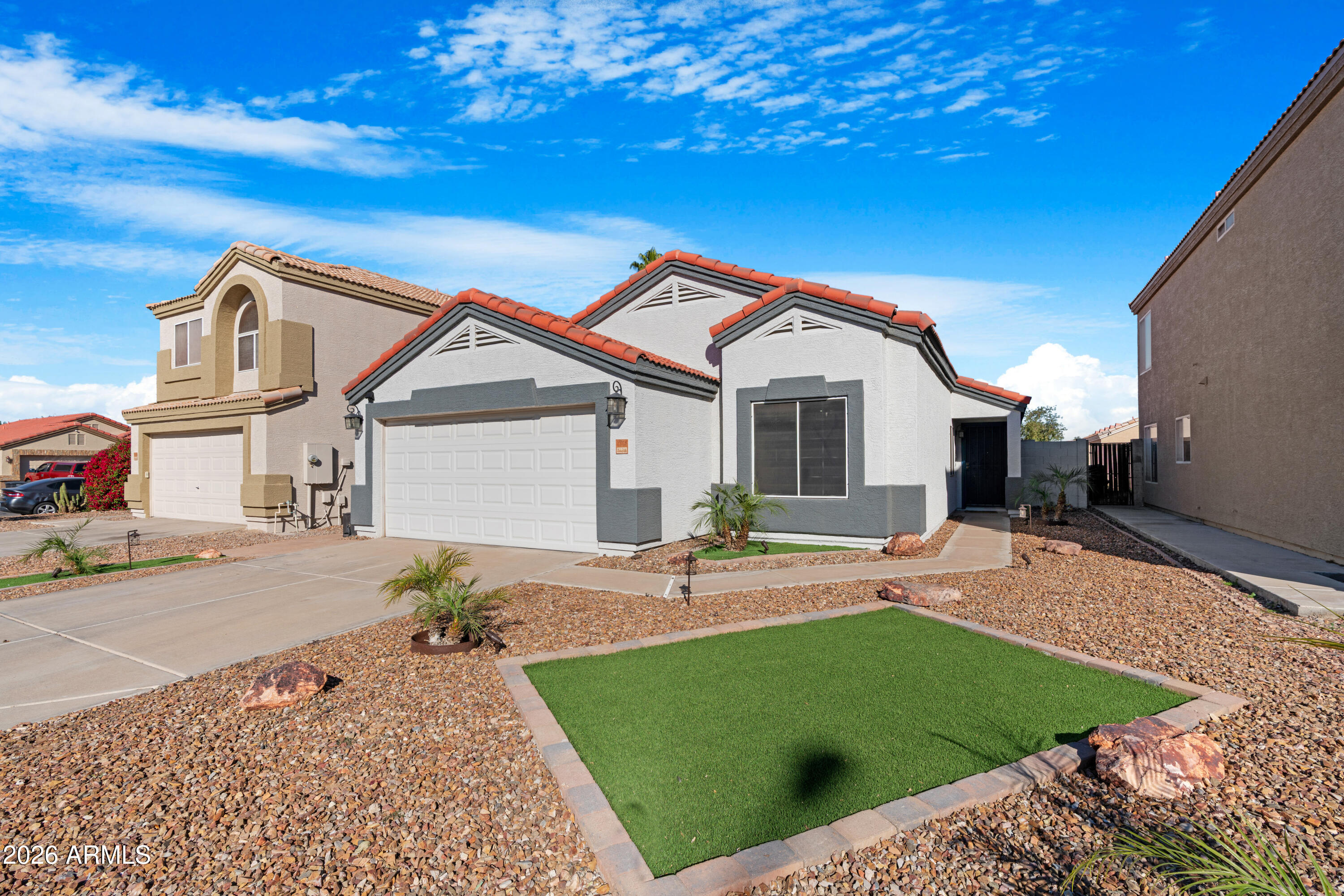 12018 West Almeria Road Avondale, AZ 85392 - Photo 3 of 39 a front view of a house with a garden and patio