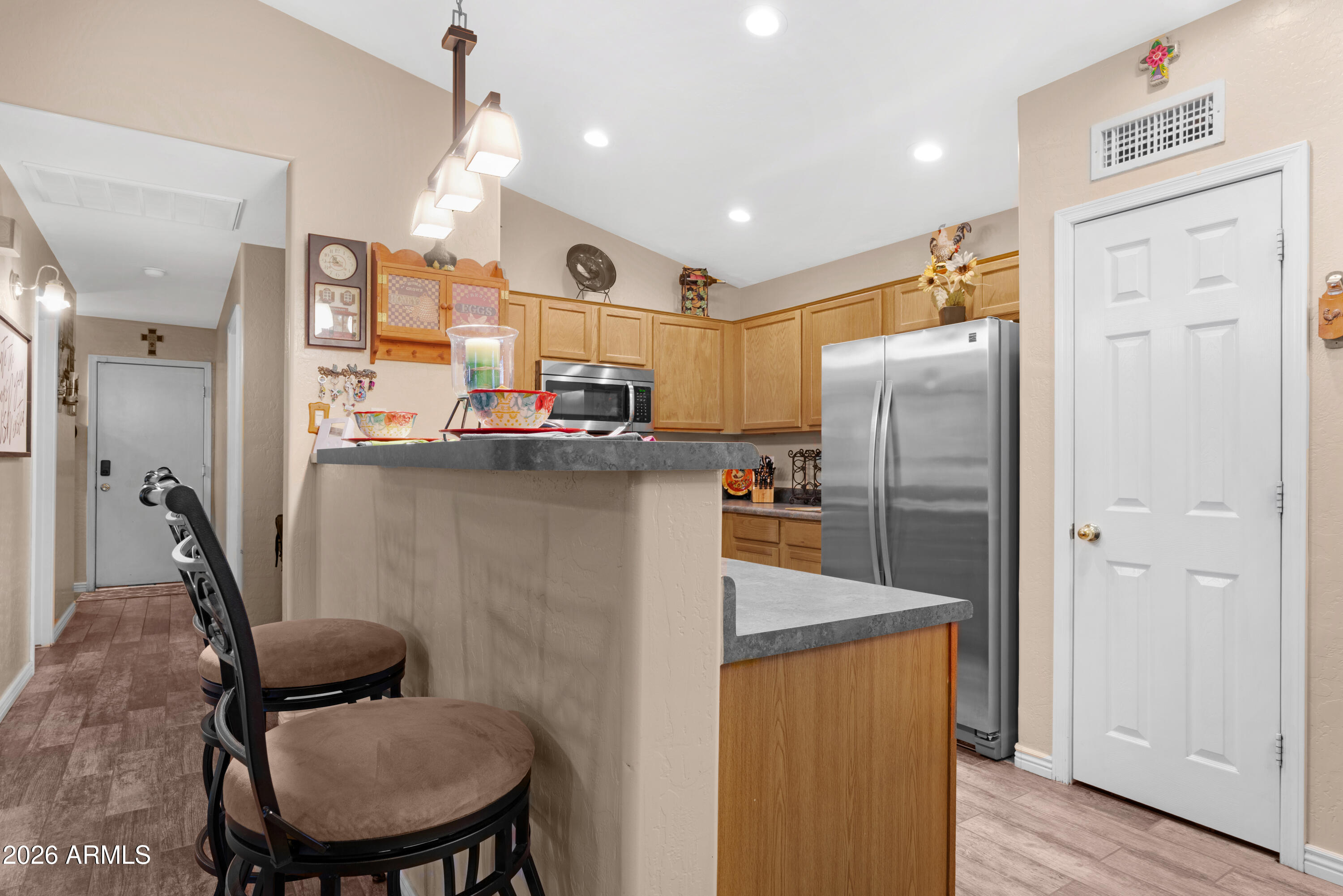 12018 West Almeria Road Avondale, AZ 85392 - Photo 8 of 39 a kitchen with refrigerator and chair