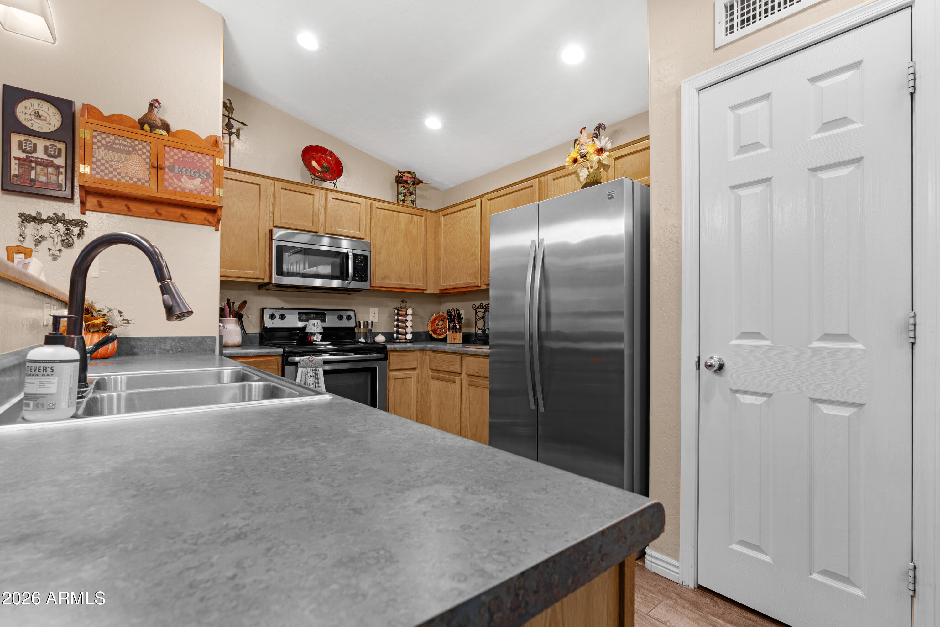 12018 West Almeria Road Avondale, AZ 85392 - Photo 9 of 39 a kitchen with granite countertop a refrigerator and a stove top oven