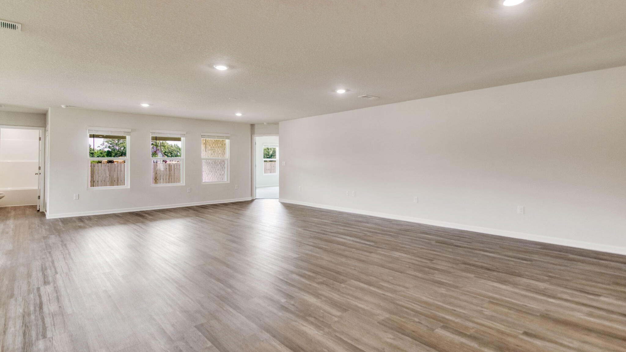 5631 Thatcher Road Crestview, FL 32539 - Photo 11 of 30 a view of an empty room with wooden floor and windows