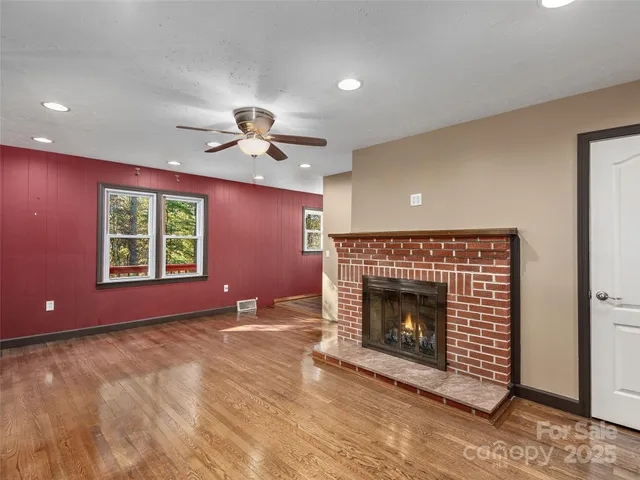 a view of an empty room with a fireplace and a window