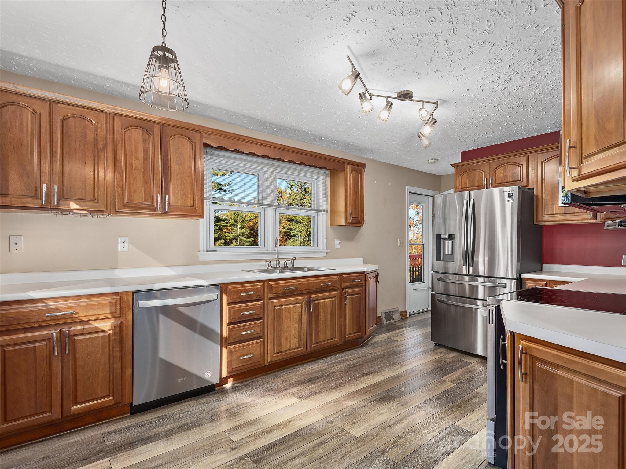 1005 Hutch Mountain Road Fletcher, NC 28732 - Photo 6 of 20 a kitchen with stainless steel appliances granite countertop a refrigerator a sink dishwasher a stove and white countertops with wooden floor