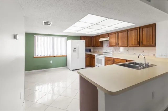 a kitchen with a sink a refrigerator and cabinets