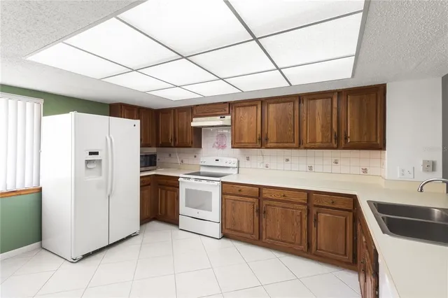 a kitchen with a sink cabinets and refrigerator