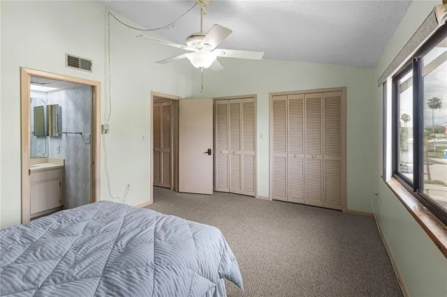 a view of a bedroom with closet and chandelier fan