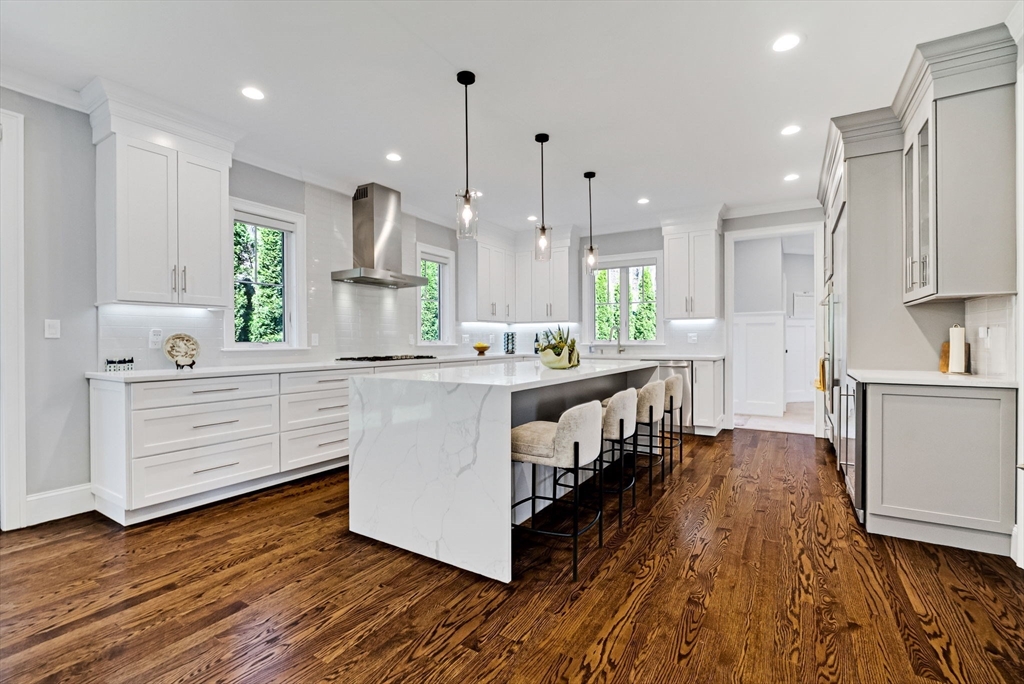 17 Sunrise Terrace Needham, MA 02492 - Photo 7 of 42 a kitchen with kitchen island granite countertop a sink cabinets and wooden floor