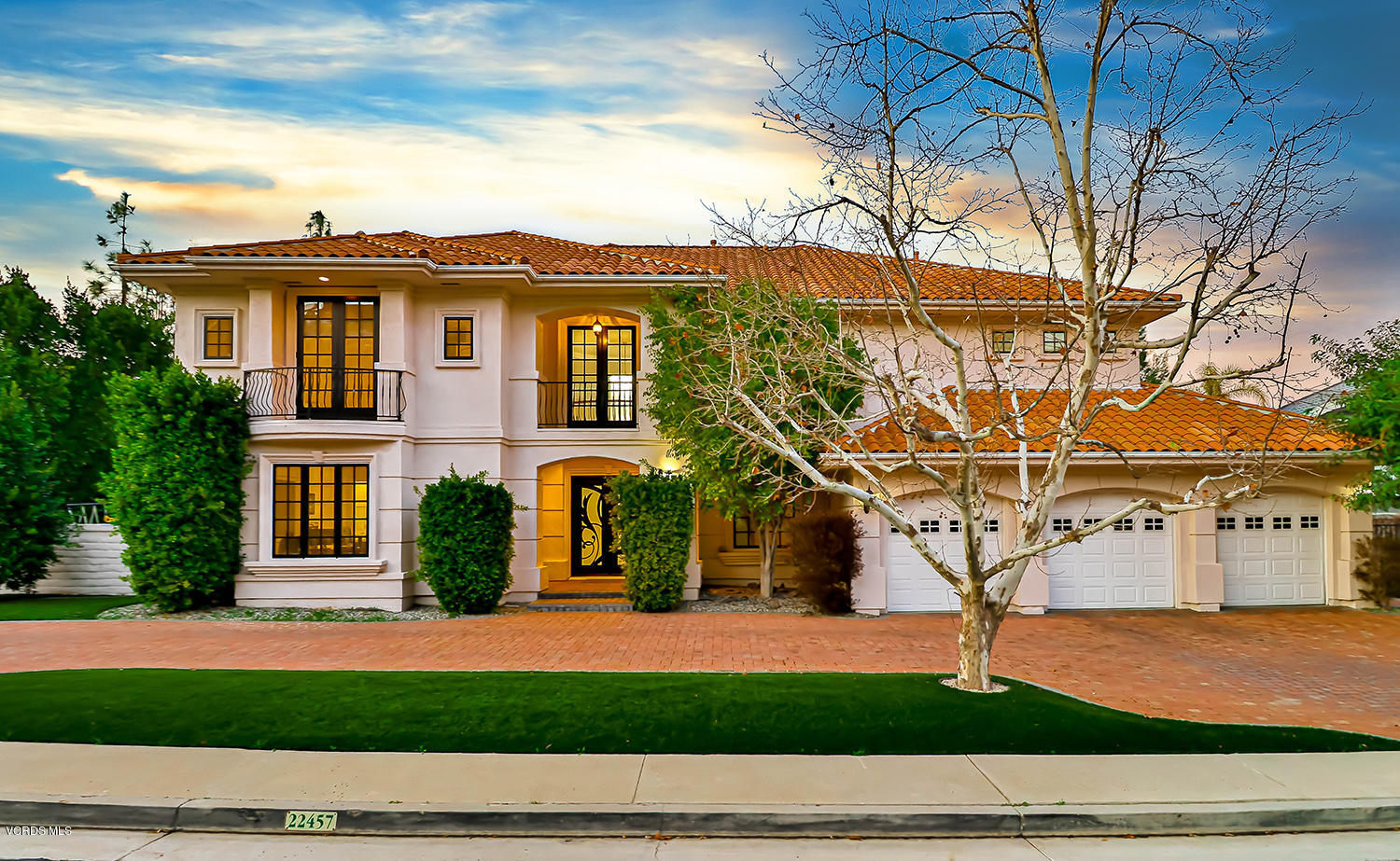 a view of a white house with a yard and parking space