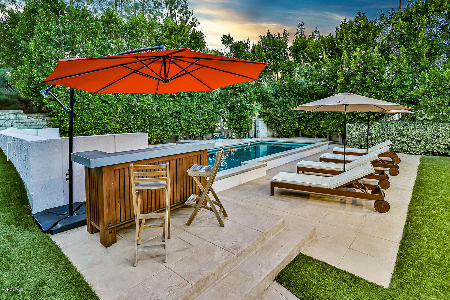 22457 North Summit Ridge Circle Chatsworth, CA 91311 - Photo 55 of 63 a backyard of a house with table and chairs under an umbrella