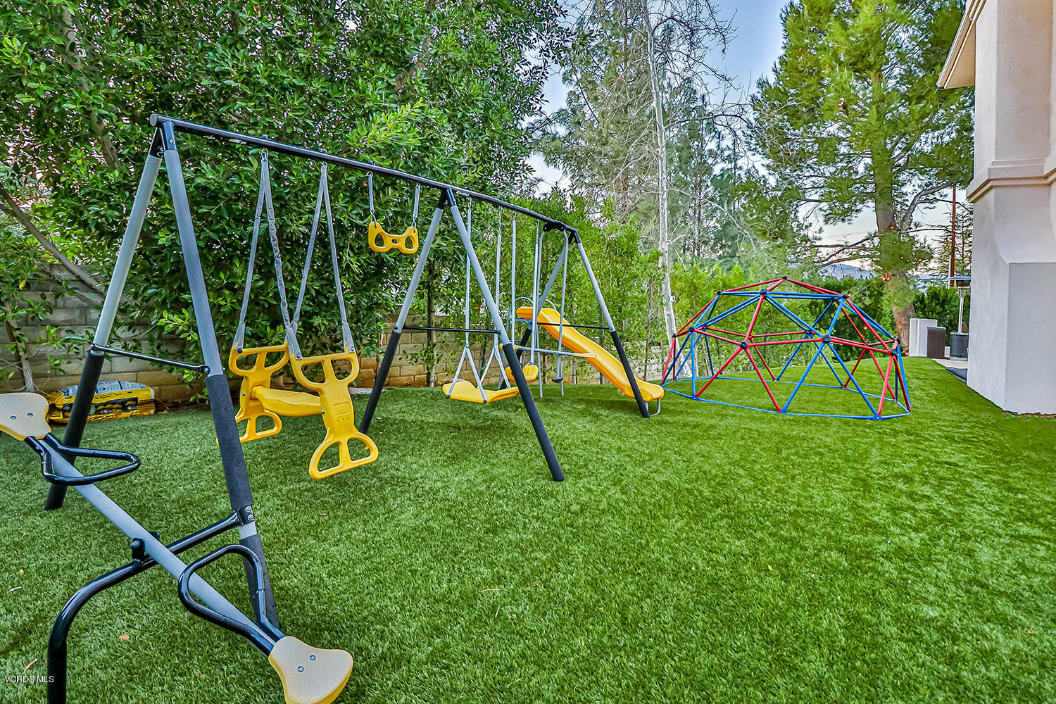 22457 North Summit Ridge Circle Chatsworth, CA 91311 - Photo 60 of 63 a view of a backyard with a slide trees and wooden fence