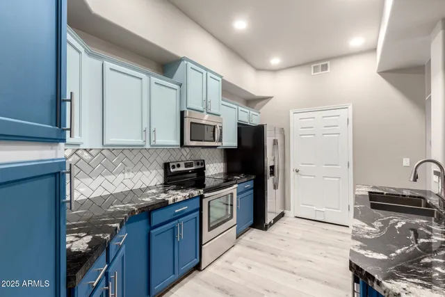a kitchen with granite countertop a sink and cabinets