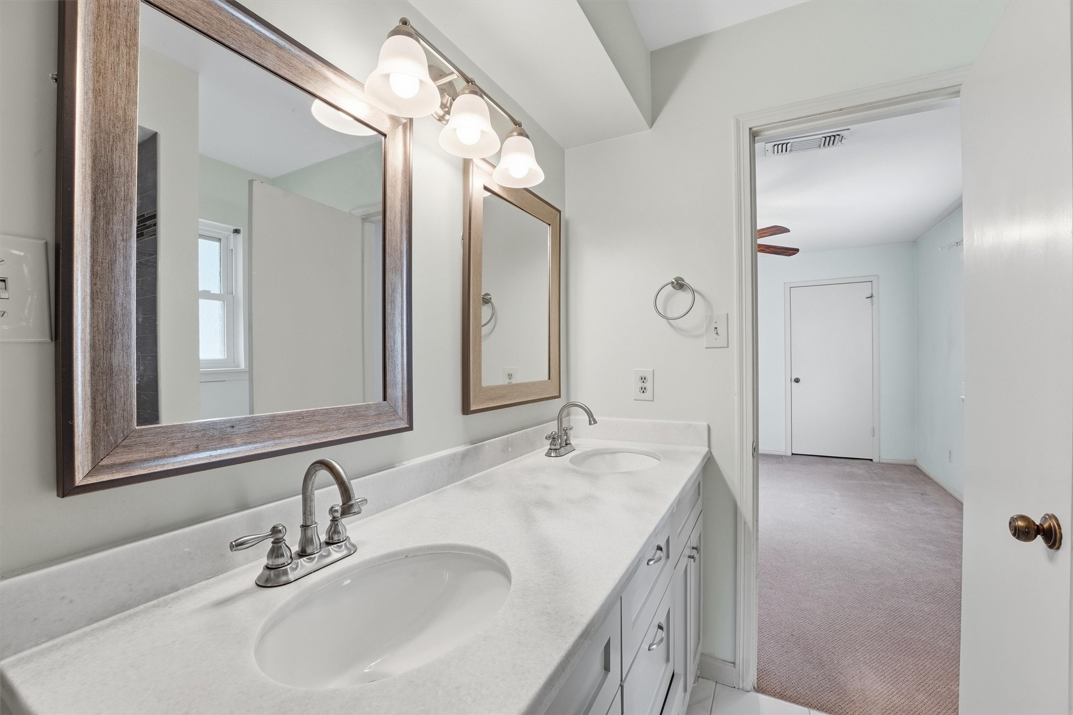8115 Theisswood Road Spring, TX 77379 - Photo 24 of 36 a bathroom with a double vanity sink and a mirror