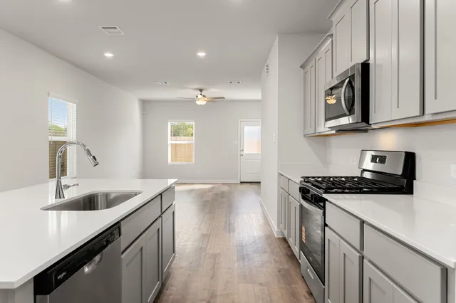 a kitchen with stainless steel appliances granite countertop a sink and stove top oven