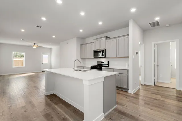 a kitchen with kitchen island a sink stainless steel appliances and cabinets