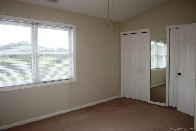 an empty room with windows and closet