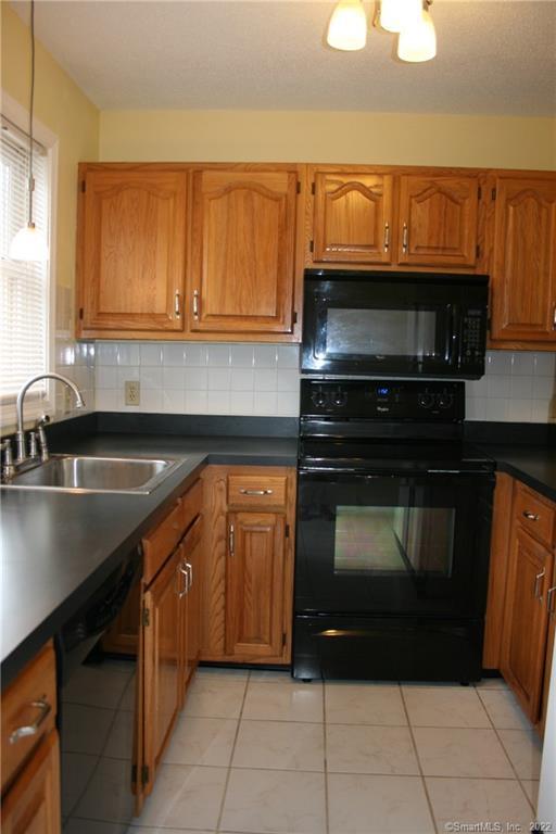92 Commodore Cmns, Unit 92 Derby, CT 06418 - Photo 5 of 21 a kitchen with a sink and a microwave