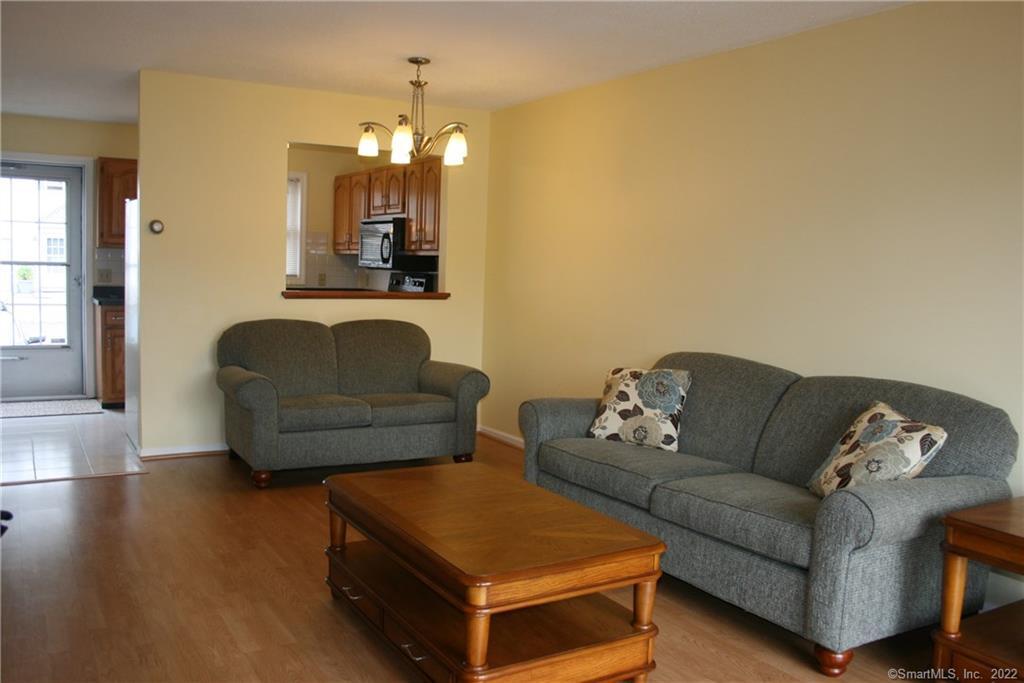 92 Commodore Cmns, Unit 92 Derby, CT 06418 - Photo 7 of 21 a living room with furniture and a chandelier