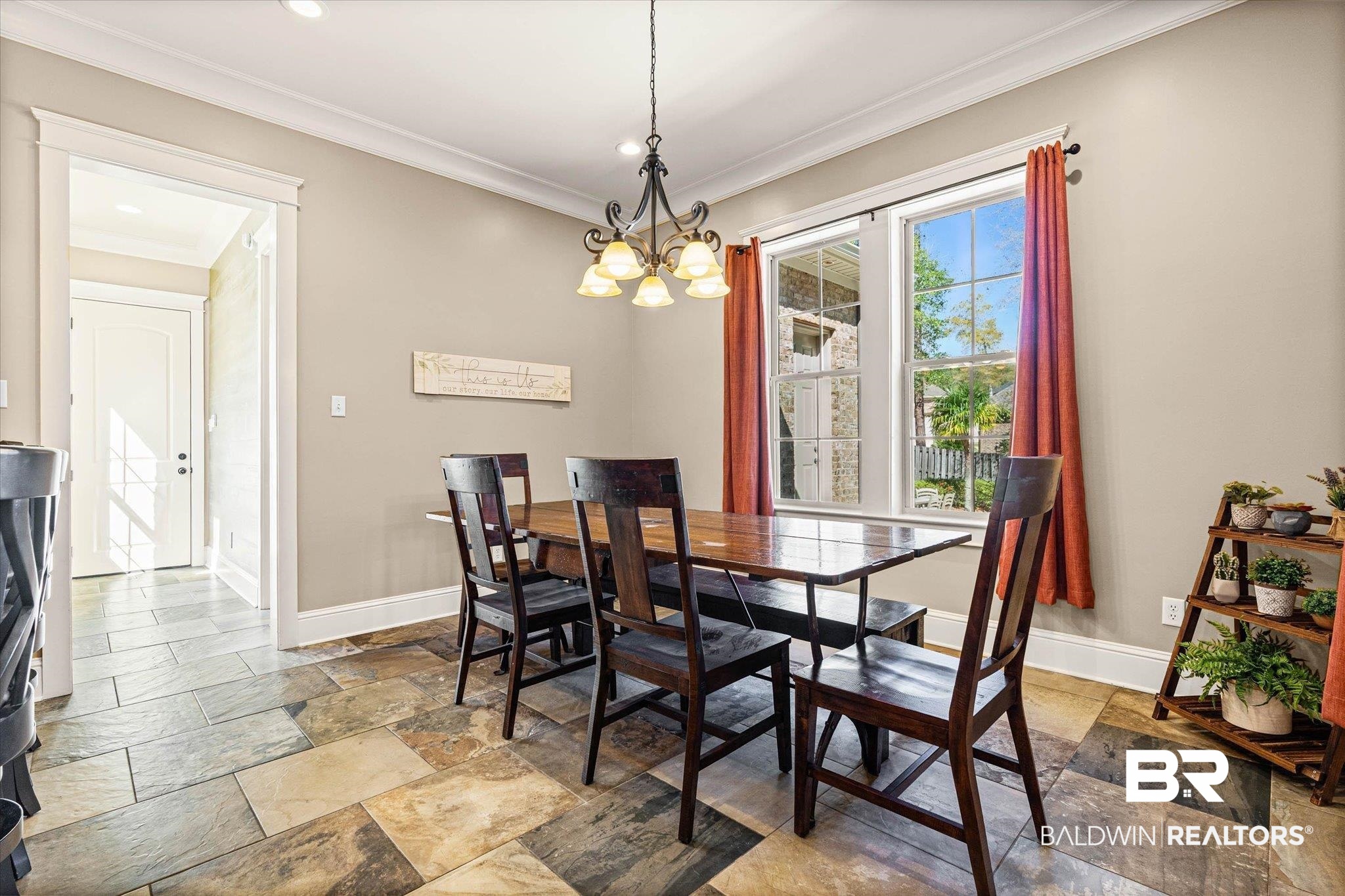 7676 Rockstone Lane Mobile, AL 36695 - Photo 14 of 47 Dining space featuring stone tile floors, ornamental molding, and a chandelier