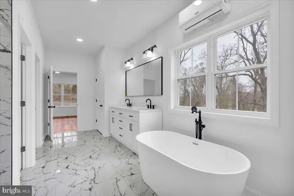 a spacious bathroom with a double vanity sink a mirror and a bathtub