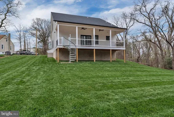a view of a house with a big yard and large trees