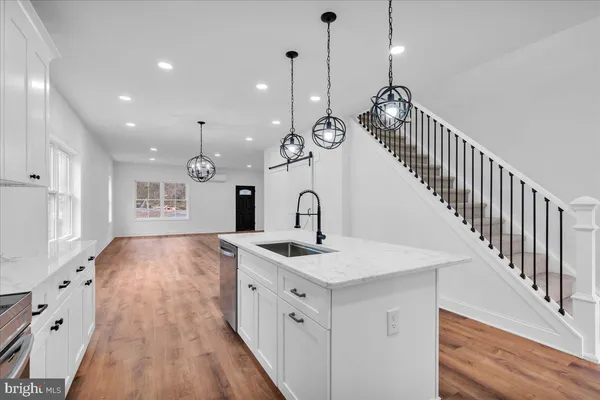 a kitchen with white cabinets sink and stainless steel appliances