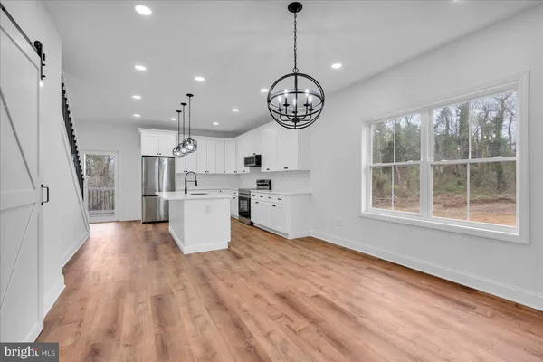 a view of a kitchen with wooden floor and electronic appliances