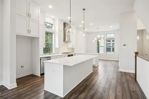 a large kitchen with stainless steel appliances kitchen island a large counter top and a wooden floors