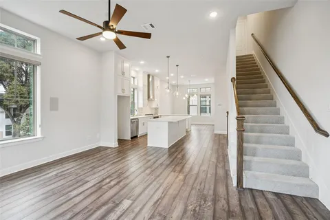 a view of a living room with wooden floor and ceiling fan