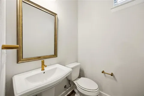 a bathroom with a sink toilet and mirror
