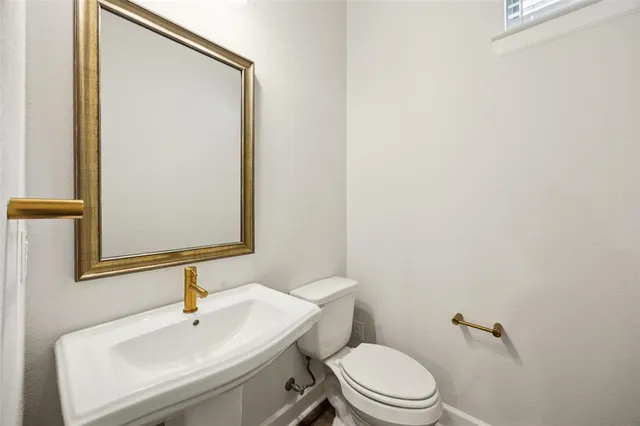 a bathroom with a sink toilet and mirror