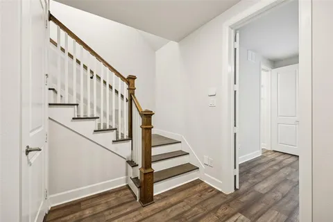 a view of a hallway with wooden floor and entryway