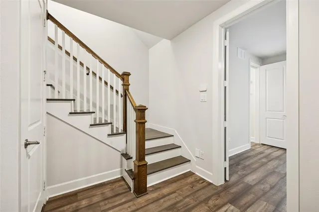 a view of a hallway with wooden floor and entryway