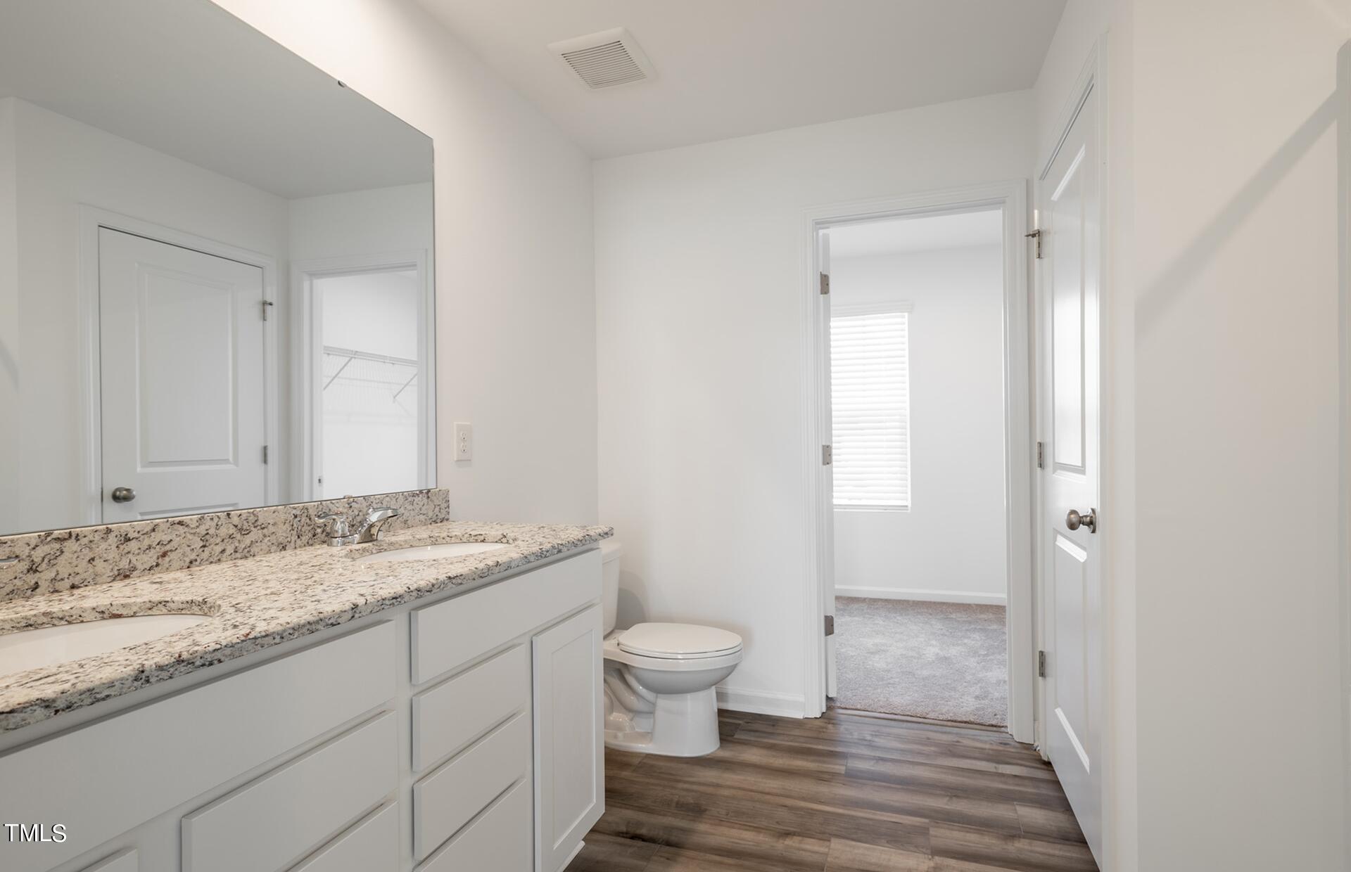 537 Campbell Rdg Place Wendell, NC 27591 - Photo 15 of 16 a bathroom with a granite countertop sink a toilet and a mirror