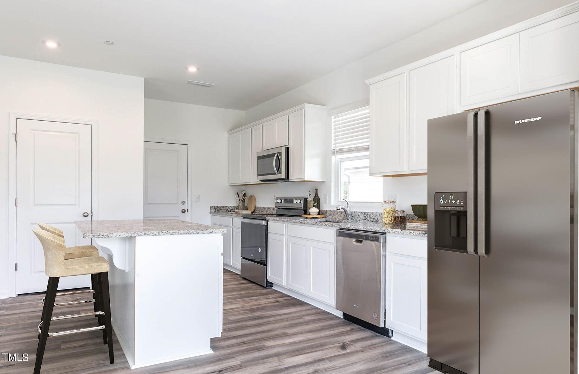537 Campbell Rdg Place Wendell, NC 27591 - Photo 3 of 16 a kitchen with a refrigerator a stove top oven a sink dishwasher and white cabinets with wooden floor