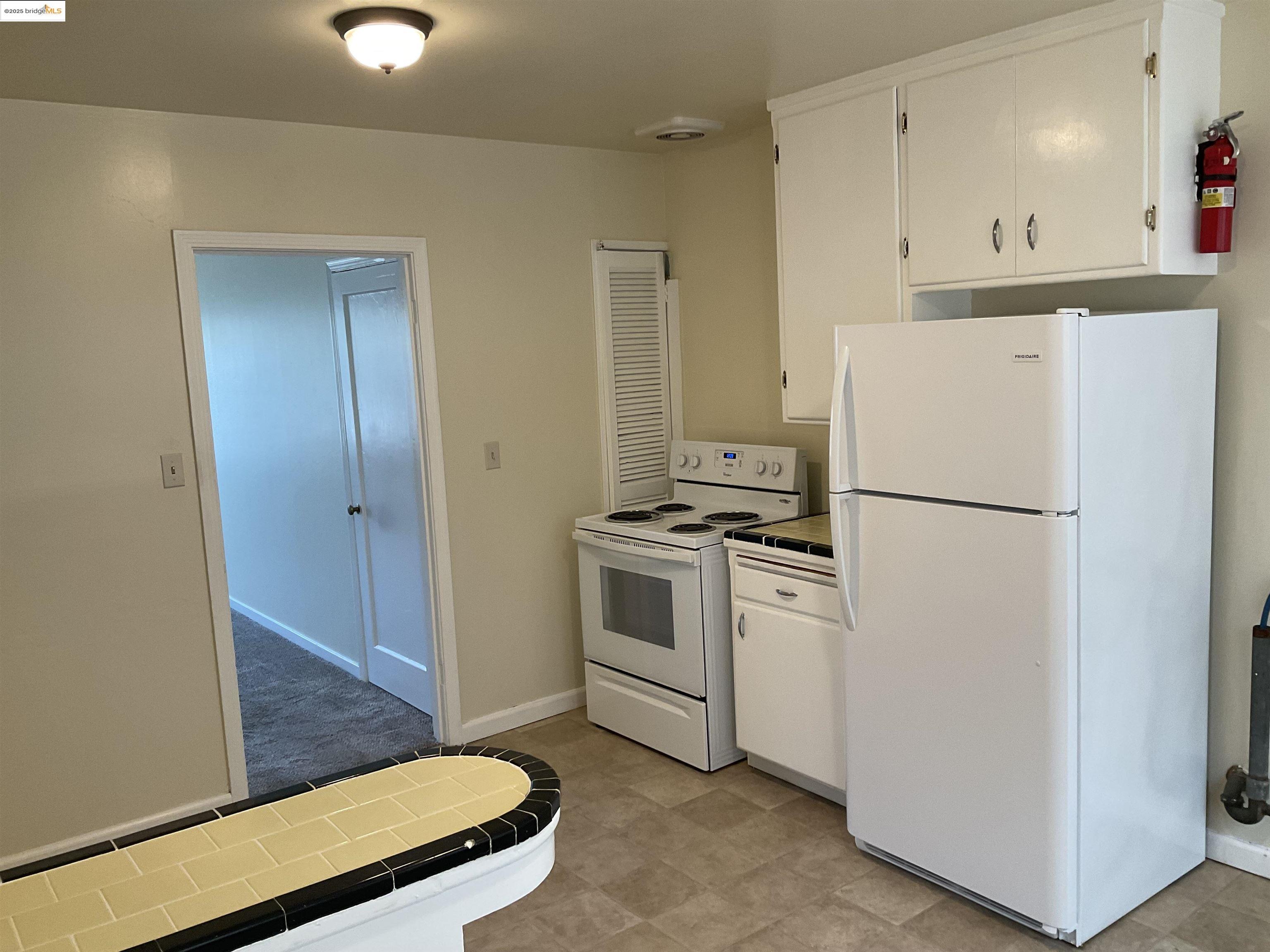 508 McLaughlin Street Richmond, CA 94805 - Photo 2 of 6 a kitchen with white cabinets and white appliances