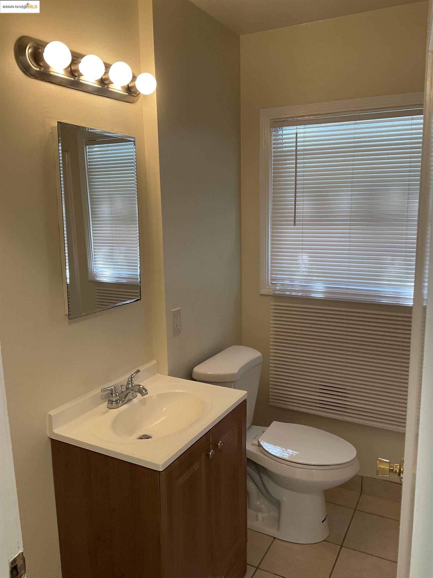 508 McLaughlin Street Richmond, CA 94805 - Photo 5 of 6 a bathroom with a sink a mirror and a toilet