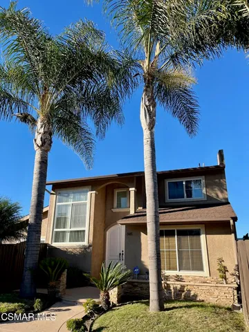a front view of a house with a yard and potted plants