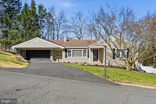a front view of a house with a garden and trees